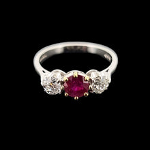 Load image into Gallery viewer, A white gold ring with a ruby and two diamonds, on a black background
