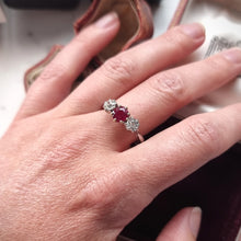 Load image into Gallery viewer, A ruby and diamond three stone ring modelled on a finger
