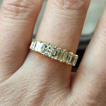 Load image into Gallery viewer, A seven stone baguette cut diamond graduated ring in yellow gold, modelled on a hand
