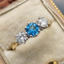 Load image into Gallery viewer, A three stone blue zircon and diamond ring in yellow and white gold, in an antique ring box
