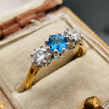 Load image into Gallery viewer, A three stone blue zircon and diamond ring in yellow and white gold, in an antique ring box
