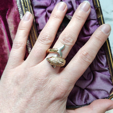 Load image into Gallery viewer, A yellow and white gold dolphin ring with diamonds and ruby eyes, modelled on a hand
