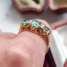 Load image into Gallery viewer, Yellow gold ring with emeralds and diamonds on a finger
