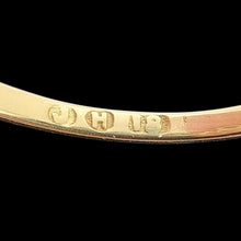 Load image into Gallery viewer, Gold ring showing the maker&#39;s mark and 18 stamp inside the shank on a black background
