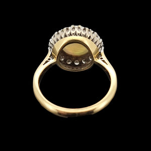 Gold ring with opal and diamond gemstones on a black background