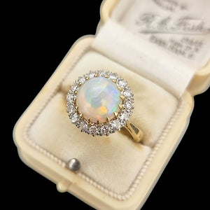 Gold ring with an opal stone and diamonds in an antique ring box