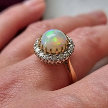 Load image into Gallery viewer, Ring with an opal stone and diamond accents on a finger
