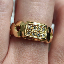 Load image into Gallery viewer, A yellow gold band with two rows of round diamonds, modelled on a hand
