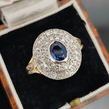 Load image into Gallery viewer, An oval sapphire and diamond cluster ring in yellow and white gold, in an antique ring box
