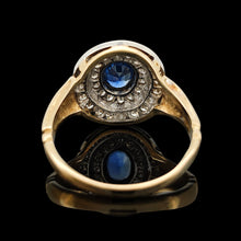 Load image into Gallery viewer, An oval sapphire and diamond cluster ring in yellow and white gold, on a black background
