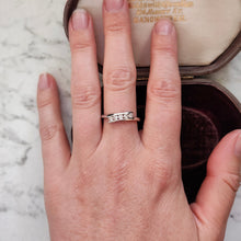 Load image into Gallery viewer, A white gold five stone diamond crossover ring, modelled on a hand
