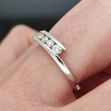 Load image into Gallery viewer, A white gold five stone diamond crossover ring, modelled on a hand
