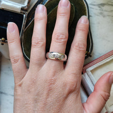Load image into Gallery viewer, A three stone star set diamond band in white gold, modelled on a hand
