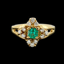 Load image into Gallery viewer, An emerald and diamond compass set cluster ring in yellow gold with split shoulders, with a black background
