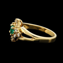 Load image into Gallery viewer, An emerald and diamond compass set cluster ring in yellow gold with split shoulders, with a black background
