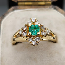 Load image into Gallery viewer, An emerald and diamond compass set cluster ring in yellow gold with split shoulders, in an antique ring box
