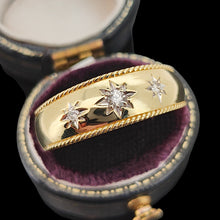 Load image into Gallery viewer, A three stone diamond star set gypsy ring in yellow gold, in a ring box, on a black background
