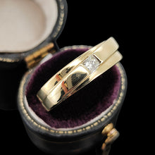 Load image into Gallery viewer, A yellow gold solitaire square cut diamond band, in a ring box, on a black background
