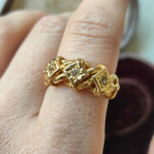 Load image into Gallery viewer, A yellow gold three stone diamond ring, modelled on a hand
