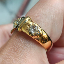 Load image into Gallery viewer, A yellow gold buckle band ring with two diamonds, modelled on a hand
