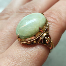 Load image into Gallery viewer, An oval, cabochon green agate dress ring in yellow gold, modelled on a hand
