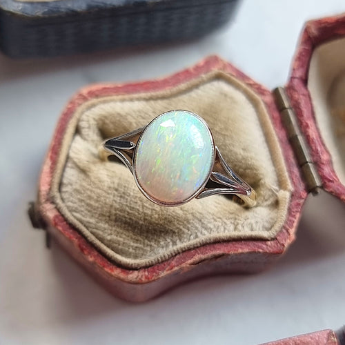 Opal ring in a decorative antique ring box on a light background
