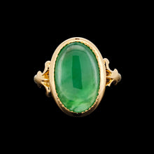 Load image into Gallery viewer, An oval shaped green jade ring in yellow gold, on a black background
