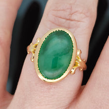 Load image into Gallery viewer, An oval shaped green jade ring in yellow gold, modelled on a hand
