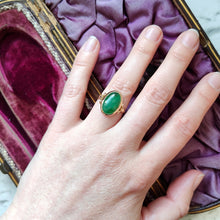 Load image into Gallery viewer, An oval shaped green jade ring in yellow gold, modelled on a hand
