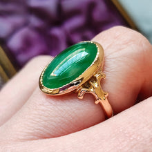 Load image into Gallery viewer, An oval shaped green jade ring in yellow gold, modelled on a hand
