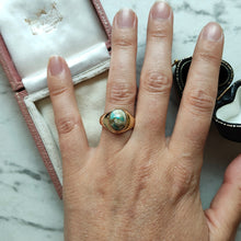 Load image into Gallery viewer, A yellow gold oval turquoise solitaire ring, modelled on a hand
