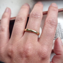Load image into Gallery viewer, Gold ring on a person&#39;s finger with a blurred background
