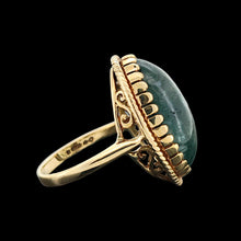 Load image into Gallery viewer, An oval moss agate ring in yellow gold, on a black background

