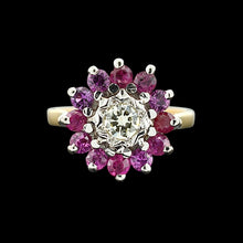 Load image into Gallery viewer, A circular ruby and diamond cluster ring in yellow and white gold, on a black background
