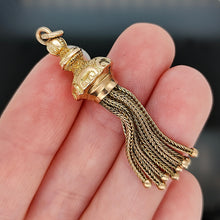Load image into Gallery viewer, A yellow gold tassel pendant with engraved detailing, held in a hand
