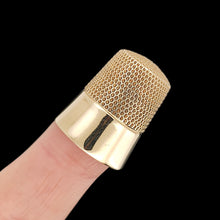 Load image into Gallery viewer, A yellow gold thimble, on an index finger, on a black background
