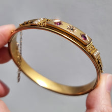 Load image into Gallery viewer, Edwardian 9ct Gold Ruby, Diamond &amp; Seed Pearl Bangle in hand
