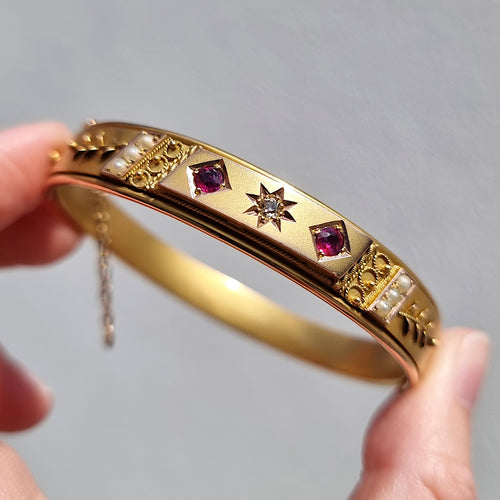 Edwardian 9ct Gold Ruby, Diamond & Seed Pearl Bangle in hand