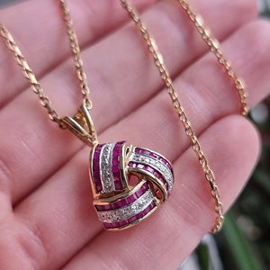 Vintage 9ct Gold Ruby and Diamond Knot Pendant in hand