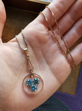 Load image into Gallery viewer, Art Deco 9ct Rose Gold Blue Zircon Pendant in hand with chain
